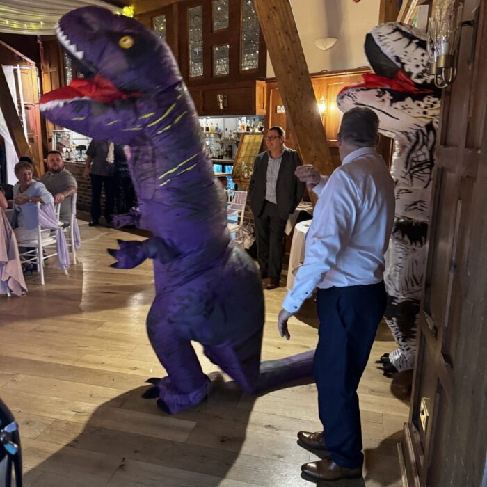 An Inflatable T-Rex stalks into a room of delighted Wedding Guests