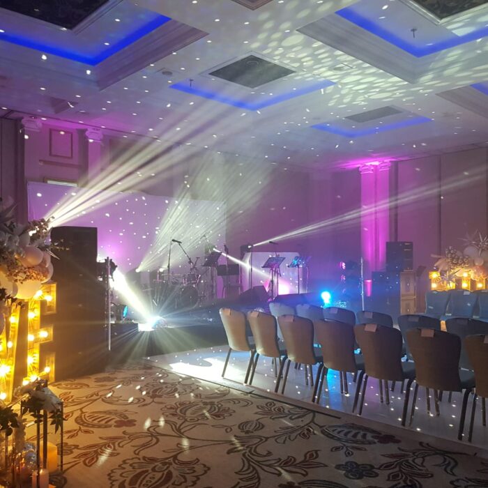 Powerful lights illuminate a ballroom for a showcase wedding