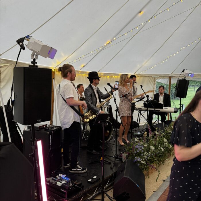 A Band Plays on a stage in a marquee
