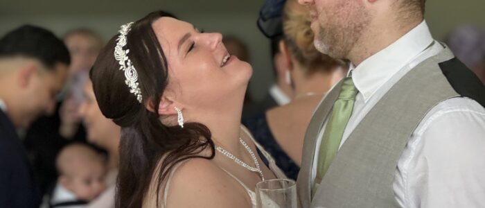 A beautiful bride and her dashing groom dance surrounded by friends and family