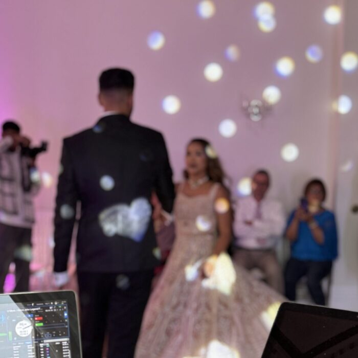 A first dance under lights; the couple are together on the floor